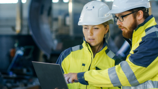 Two compressed air equipment workers reviewing a tablet